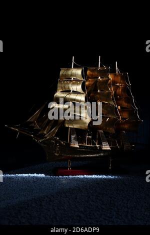 Statuetta di una nave a vela. Un primo piano di una grande nave in colore dorato. Modello di spedizione. Collezione d'arte. Foto di alta qualità Foto Stock