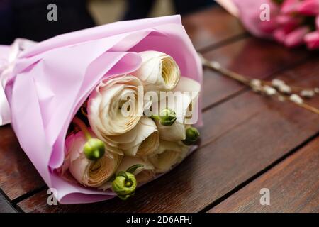 Bouquet di tulipani bianchi e rosa. Due bouquet di fiori giacenti su un tavolo di legno. Idea di base per un biglietto di auguri. Primavera Foto Stock