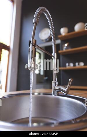 Primo piano di un rubinetto di cucina con acqua corrente Foto Stock