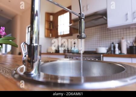 Primo piano di un rubinetto di cucina con acqua corrente Foto Stock