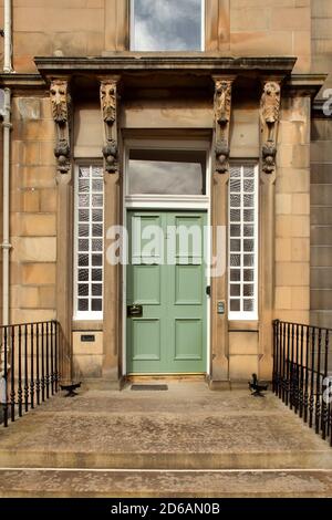 Porta di fronte in legno verde su un edificio residenziale nell'area di Stockbridge di Edinburgo, Scozia. Foto Stock