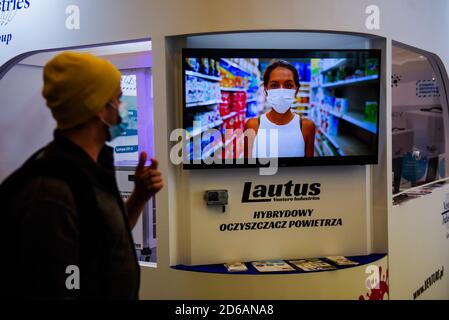 Cracovia, Polonia. 15 Ott 2020. Un uomo che indossa una maschera facciale cammina da una pubblicità a Cracovia EXPO.During due giorni, la fiera Anti COVID porta con prodotti e soluzioni che fornirà adeguata protezione per i dipendenti e i membri della famiglia durante il romanzo del coronavirus. Credit: SOPA Images Limited/Alamy Live News Foto Stock