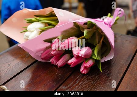 Bouquet di tulipani bianchi e rosa. Due bouquet di fiori giacenti su un tavolo di legno. Idea di base per un biglietto di auguri. Primavera Foto Stock