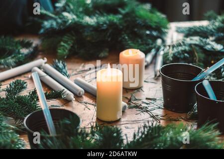 bruciare candele, forbici e ramoscelli verdi componenti su tavola di legno Foto Stock