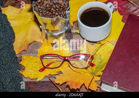 Caffè caldo in tazzina rossa con vapore e occhiali su libri impilati sfondo di legno, concetto di pausa caffè Foto Stock