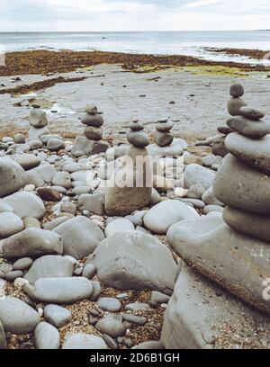 Rocce accatastate in una formazione still in piedi, ciottoli dalla spiaggia messi uno su un altro come hig possibile, gruppi di pietre in posizioni verticali Foto Stock