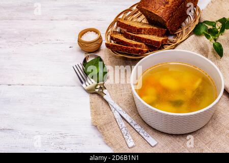 Zuppa di trote con verdure da taglio e pane tostato. Zuppa tradizionale di pesce caldo per uno stile di vita sano. Sfondo bianco tavole di legno, spazio copia Foto Stock