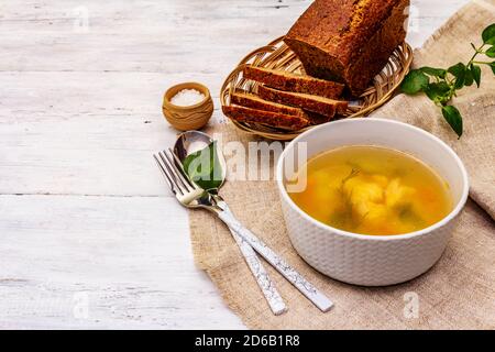 Zuppa di trote con verdure da taglio e pane tostato. Zuppa tradizionale di pesce caldo per uno stile di vita sano. Sfondo bianco tavole di legno, spazio copia Foto Stock