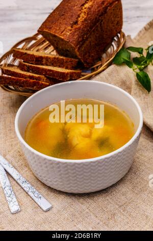 Zuppa di trote con verdure da taglio e pane tostato. Zuppa tradizionale di pesce caldo per uno stile di vita sano. Bianco legno sfondo tavole, primo piano Foto Stock