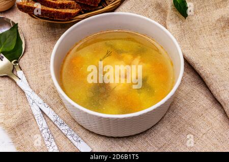 Zuppa di trote con verdure da taglio e pane tostato. Zuppa tradizionale di pesce caldo per uno stile di vita sano. Bianco legno sfondo tavole, primo piano Foto Stock