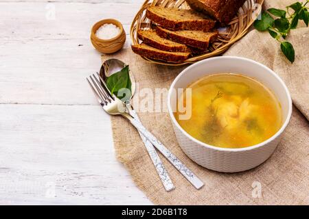 Zuppa di trote con verdure da taglio e pane tostato. Zuppa tradizionale di pesce caldo per uno stile di vita sano. Sfondo bianco tavole di legno, spazio copia Foto Stock