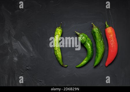 Peperoni caldi viziati su sfondo scuro. Cibo brutto. Spazio per il testo Foto Stock