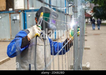 Saldatore funzionante cuoce strutture metalliche. Il processo di saldatura dei prodotti metallici Foto Stock