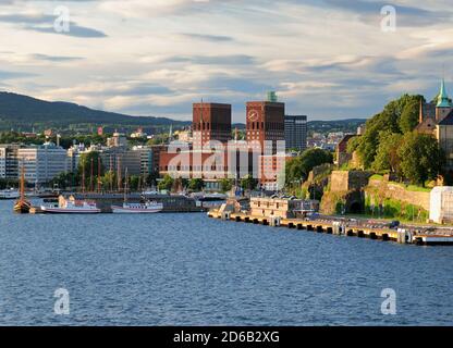 Vista dal Oslofjord al Municipio in mattoni rossi Il porto di Oslo in UN giorno estivo soleggiato con Un cielo azzurro e alcune nuvole Foto Stock