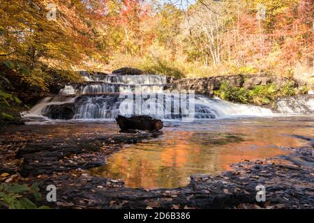 Il peak fall foliage circonda le belle cascate Shohola Falls su un Autunno mattina nella Pennsylvania Poconos Foto Stock