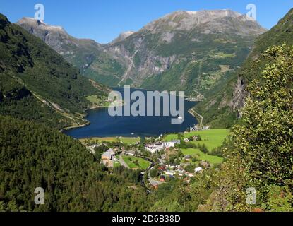 Vista dal Flydalsjuvet Lookout al Geiranger Village e Geirangerfjord on Un giorno estivo soleggiato con un cielo azzurro Foto Stock