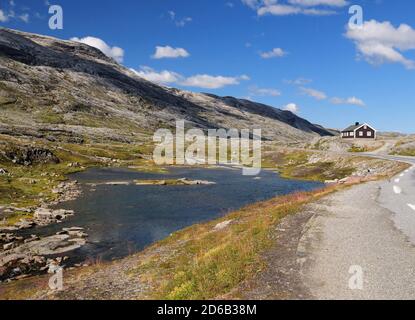 Paesaggio arido sulla strada per Dalsnibba vicino Geiranger ON Un giorno estivo soleggiato con un cielo azzurro chiaro e. Alcune nuvole Foto Stock