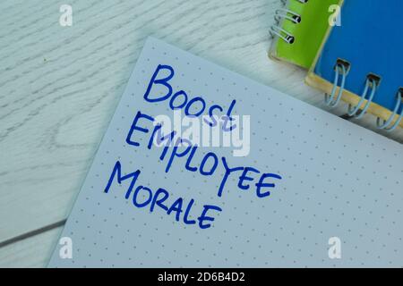 Aumenta il morale dei dipendenti scrivere su un libro isolato sulla scrivania dell'ufficio. Foto Stock