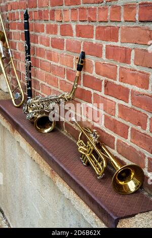 Strumenti musicali tra cui clarinetto tromba trombone e sassofono sulla parete di mattoni fuori dal Jazz club Foto Stock