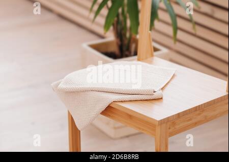 asciugamano beige naturale ripiegato su tavolo da bagno in legno. elementi di arredo bagno con materiali naturali. Minimalismo in ristrutturazione Foto Stock