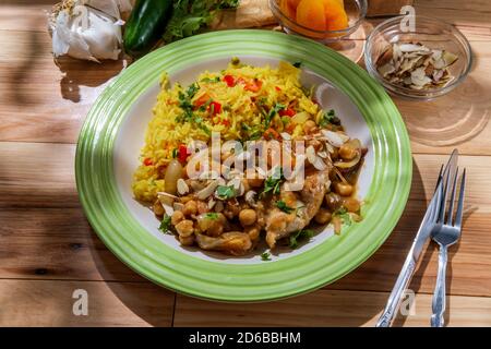 Cucina marocchina cosce di pollo in un piccante ceci data e. salsa di albicocche essiccate a fette di mandorle per guarnire Foto Stock