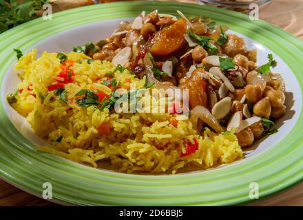 Cucina marocchina cosce di pollo in un piccante ceci data e. salsa di albicocche essiccate a fette di mandorle per guarnire Foto Stock