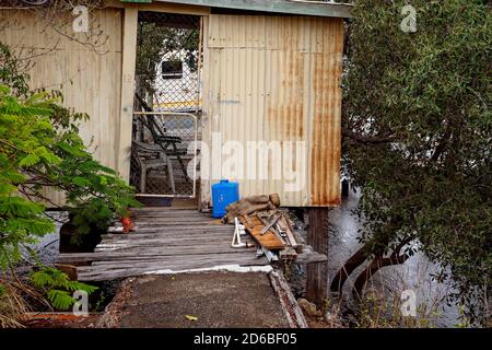 Yamba, Queensland, Australia - Dicembre 2019: una vecchia capanna pieno di spazzatura costruita molti anni fa come un pontile sulle rive di un ruscello, ancora oggi utilizzato Foto Stock