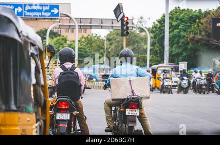I motociclisti aspettano all'incrocio di Valluvar Kottam. Traffico sfocato in background Foto Stock