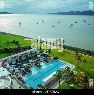 Townsville, Queensland, Australia - Giugno 2020: Vista aerea della piscina di lusso dell'hotel resort vicino al mare con barche ormeggiate lungo la costa Foto Stock