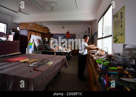 (201016) -- LUXI, 16 ottobre 2020 (Xinhua) -- li Xuezhan prepara i materiali per fare i sussidi didattici alla scuola nella contea di Luxi, nella provincia di Jiangxi della Cina orientale, 14 ottobre 2020. Ogni volta che li Xuezhan entra nella scuola centrale nella città di Xuanfeng della contea di Luxi con la sua valigia piena di sussidi didattici fatti a mano, sarà seguito e circondato da studenti. Li, 58 anni, divenne insegnante di scienze nel 1996. A causa della mancanza di ausili didattici, ha dovuto raccogliere bottiglie vuote, legno, pneumatici rotti e trasformarli in ausili didattici per la classe scientifica. Ora che le condizioni di insegnamento della scuola sono migliorate, li Foto Stock