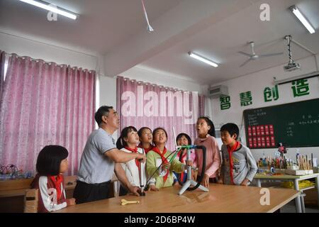 (201016) -- LUXI, 16 ottobre 2020 (Xinhua) -- li Xuezhan (2° L) insegna agli studenti meccanica con il suo sussidio didattico fatto a mano a scuola nella contea di Luxi, nella provincia di Jiangxi della Cina orientale, 14 ottobre 2020. Ogni volta che li Xuezhan entra nella scuola centrale nella città di Xuanfeng della contea di Luxi con la sua valigia piena di sussidi didattici fatti a mano, sarà seguito e circondato da studenti. Li, 58 anni, divenne insegnante di scienze nel 1996. A causa della mancanza di ausili didattici, ha dovuto raccogliere bottiglie vuote, legno, pneumatici rotti e trasformarli in ausili didattici per la classe scientifica. Ora come la scuola di insegnamento con Foto Stock