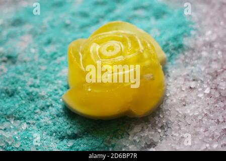 Saponetta gialla naturale fatta a mano sotto forma di rosa su profumato fondo di sale marino. Foto Stock