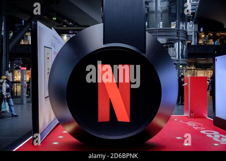 Cuffie enormi con il logo di Netflix, che presentano servizi multimediali e notizie in un enorme centro commerciale Foto Stock
