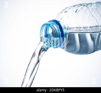 Primo piano dell'acqua che fuoriesce da una bottiglia di plastica su sfondo bianco Foto Stock