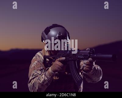 soldato con armi e equipaggiamento militare completo e equipaggiamento da combattimento in missione notturna Foto Stock