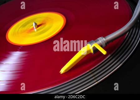 Vinile rosso su un lettore di dischi con pickup giallo. Foto Stock