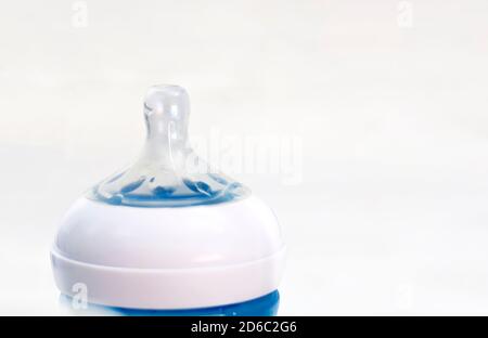 la tettarella in silicone trasparente di un biberon blu isolato su sfondo bianco. Foto Stock