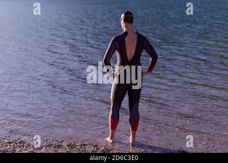 autentico ritratto del nuotatore triatleta che indossa una muta per l'allenamento mattutino Foto Stock