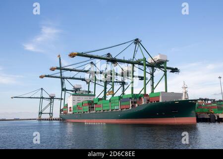 Logistica e trasporto di container merci esportazione nave importazione con ponte di gru funzionante in cantiere in giornata di sole Foto Stock