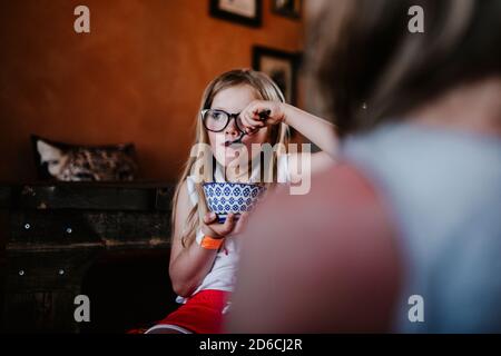 Ragazza che tiene la ciotola e che mangia Foto Stock