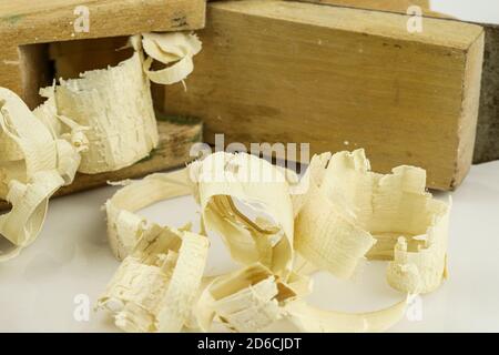 Particolare del tradizionale piano-martinetto in legno con segatura in legno isolata su sfondo bianco. Vecchio piano martinetto manuale e trucioli di legno. Foto Stock