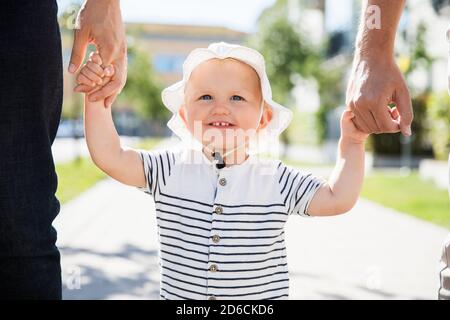 Bambino che cammina con i padri Foto Stock