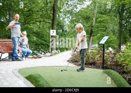 Ragazzo giocando a minigolf Foto Stock