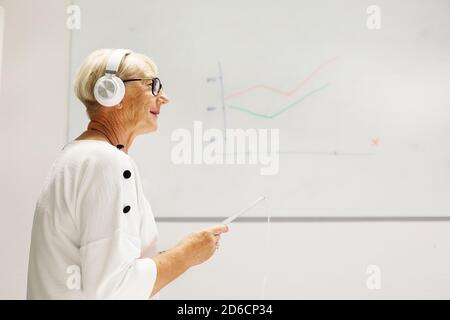 Donna anziana che ascolta musica Foto Stock
