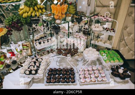 Dolci deliziosi di vari colori in un bar caramelle in occasione di un matrimonio. Dolce tavolo. Buffet di nozze. Foto Stock