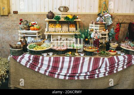 Tavolo da catering decorato in stile rustico ucraino con diversi spuntini e antipasti. Foto Stock