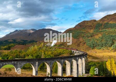 FORT WILLIAM WEST COAST OF SCOTLAND IL TRENO A VAPORE JACOBITE LASCIANDO IL VIADOTTO GLENFINNAN CON I COLORI AUTUNNALI NEL PAESAGGIO Foto Stock