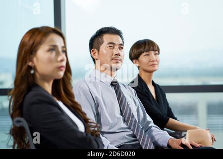 dirigenti aziendali asiatici che ascoltano attentamente durante la presentazione o la formazione Foto Stock