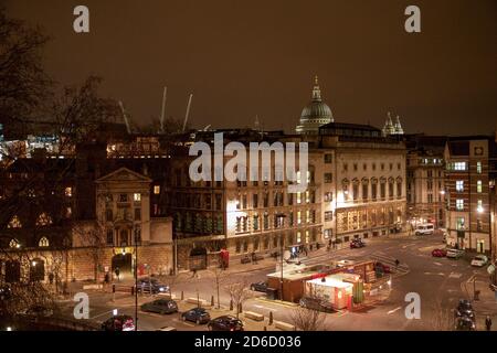 Vista dall'alto di un edificio nelle vicinanze mostra il St Bartholemew's Hospital di Smithfield nella città di Londra illuminato da luci di strada sodiche di notte con la cupola della Cattedrale di San Paolo a metà distanza illuminata contro il cielo inquinato dalla luce. 21 gennaio 2009. Foto: Neil Turner Foto Stock