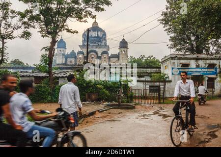 Khajuraho, Madhya Pradesh, India : i locali pedalano sulle strade bagnate di Khajuraho durante la stagione delle piogge monsonine. Foto Stock